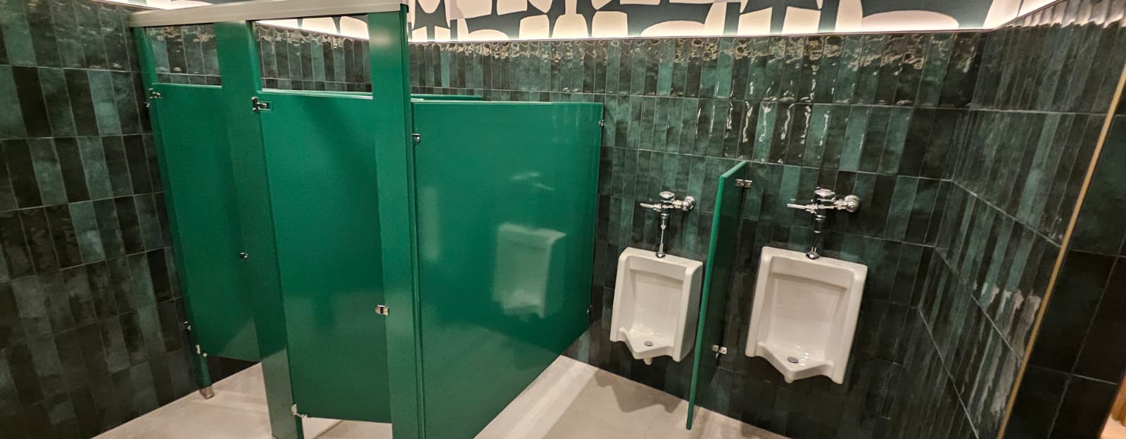 Forest green powder-coated steel restroom stalls and urinal screens at Casa Mezcal in Orlando, Florida
