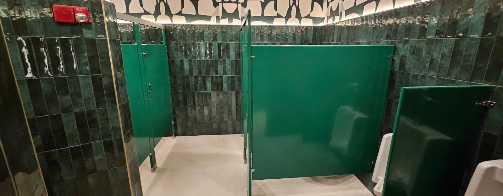 Forest green powder-coated steel restroom stalls at Casa Mezcal in Orlando, Florida