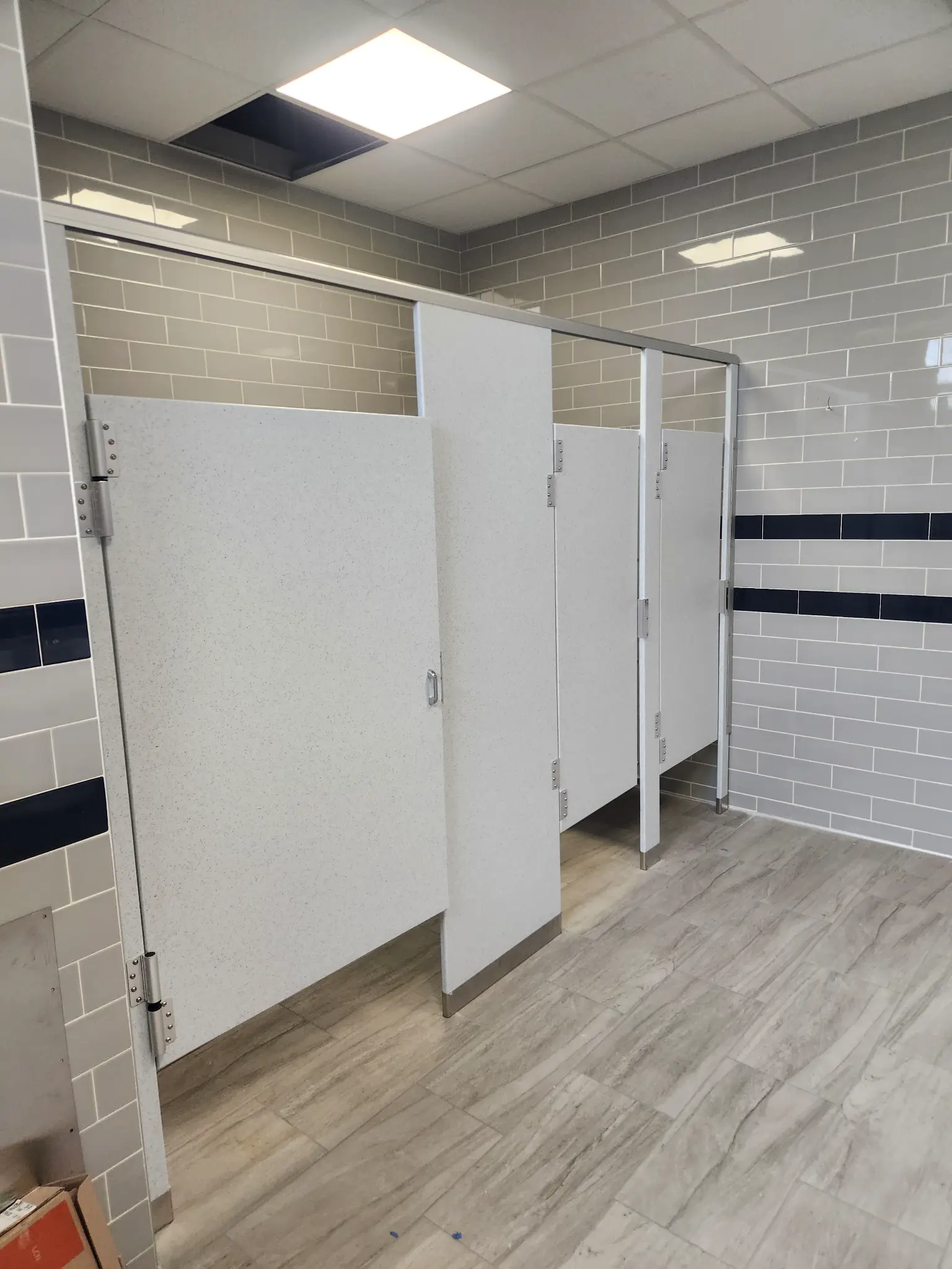 White solid-plastic commercial restroom stalls at Hewlett-Woodmere Public Schools in Woodmere, New York