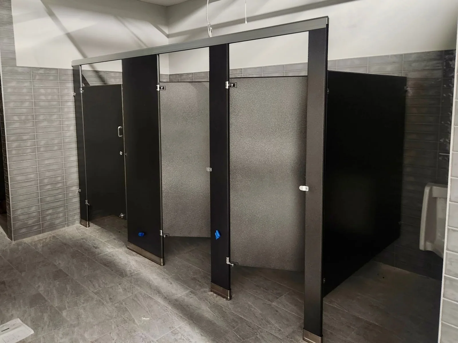 Additional view of brown powder-coated-steel commercial restroom stalls and screens at Training Station Athletic Clubs in Port Washington, New York