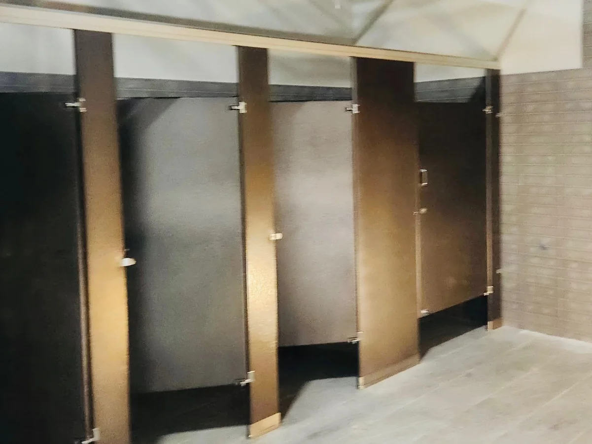 Brown powder-coated-steel commercial restroom stalls at Training Station Athletic Clubs in Port Washington, New York