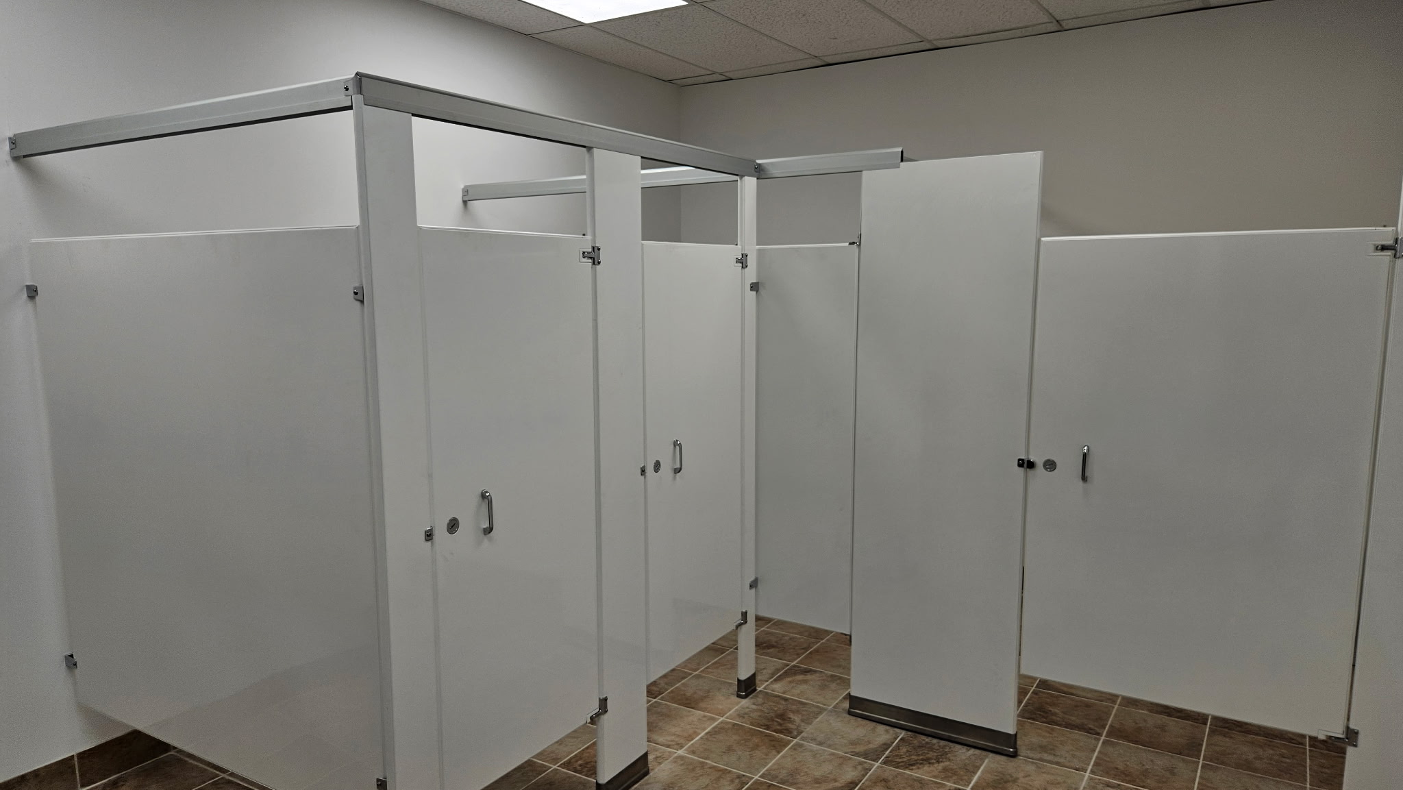White solid-plastic HDPE commercial restroom stalls at the YouthBuild Newark project in Newark, New Jersey