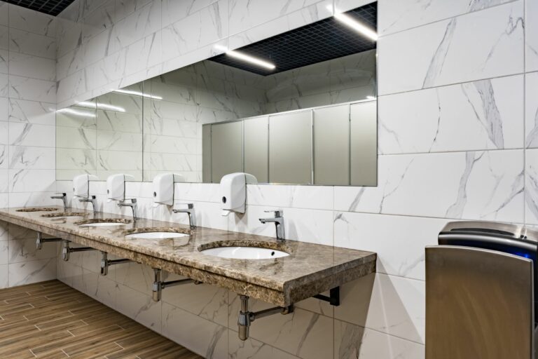 Modern sinks with mirror in public toilet, close up